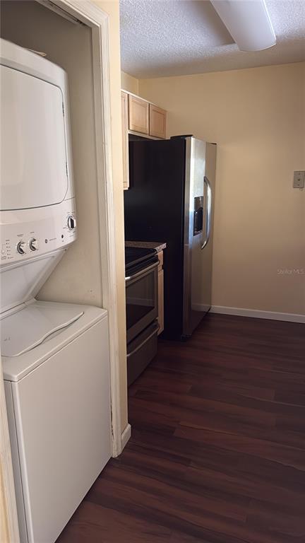A stacked washer and dryer unit sits in a closet next to a kitchen area — 3950 SOUTHPOINTE DRIVE UNIT 418, ORLANDO, FL