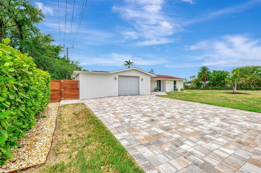A single-story house with a paved driveway, a one-car garage, and a wooden fence — 2920 GULF GATE DRIVE, SARASOTA, FL