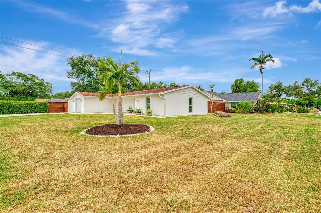 A single-story white house with a red roof sits on a large grassy lot — 2920 GULF GATE DRIVE, SARASOTA, FL