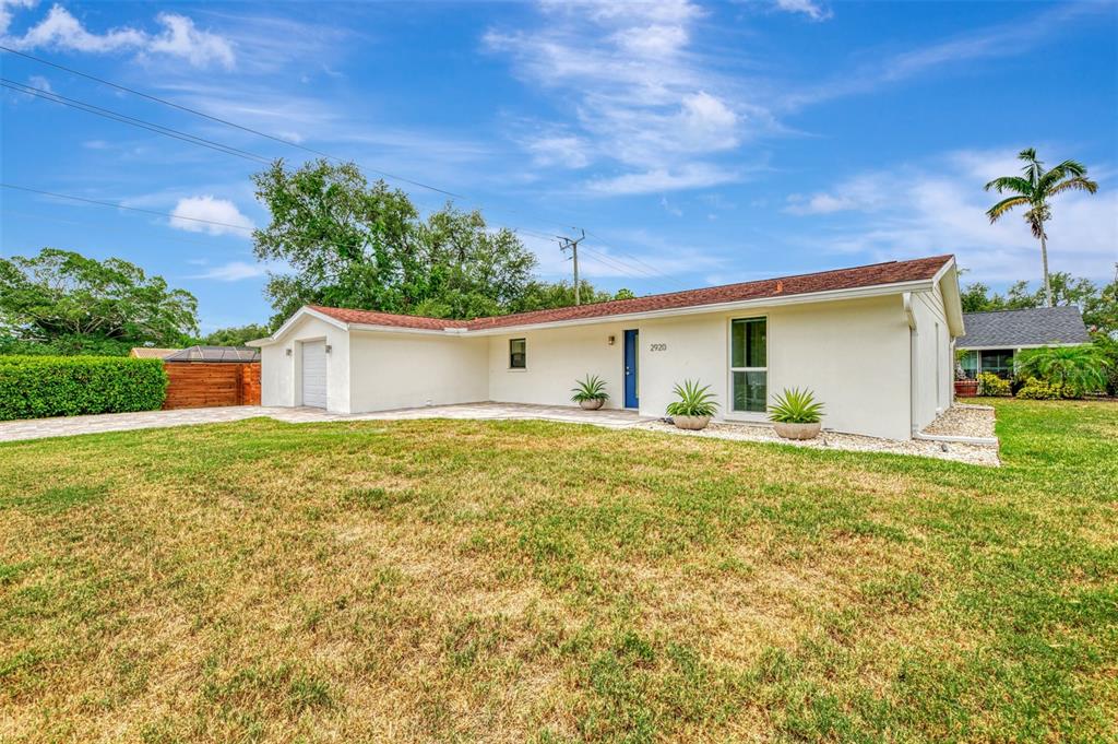 A single-story house with a white exterior, a brown roof, and a front lawn — 2920 GULF GATE DRIVE, SARASOTA, FL