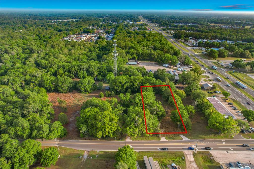 An aerial view shows a rectangular plot of land outlined in red near a road — 1215 DUFF ROAD, LAKELAND, FL