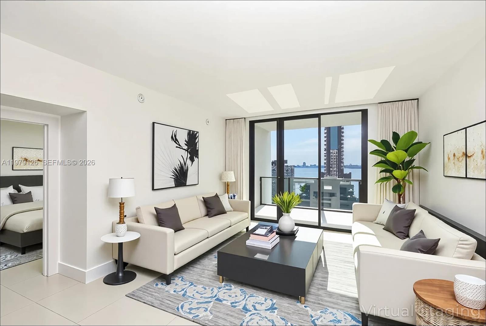 This living room features a sofa, coffee table, and a balcony with a water view — 1010 Brickell Ave # 1902, Miami FL 33131, MIAMI, FL