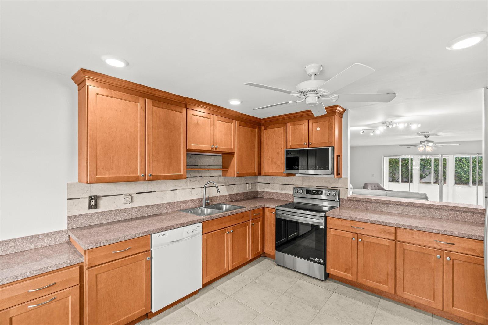 A kitchen with wood cabinets, laminate countertops, stainless steel appliances, and a white dishwasher — 5074 Privet Place # B, Delray Beach FL 33484, DELRAY BEACH, FL