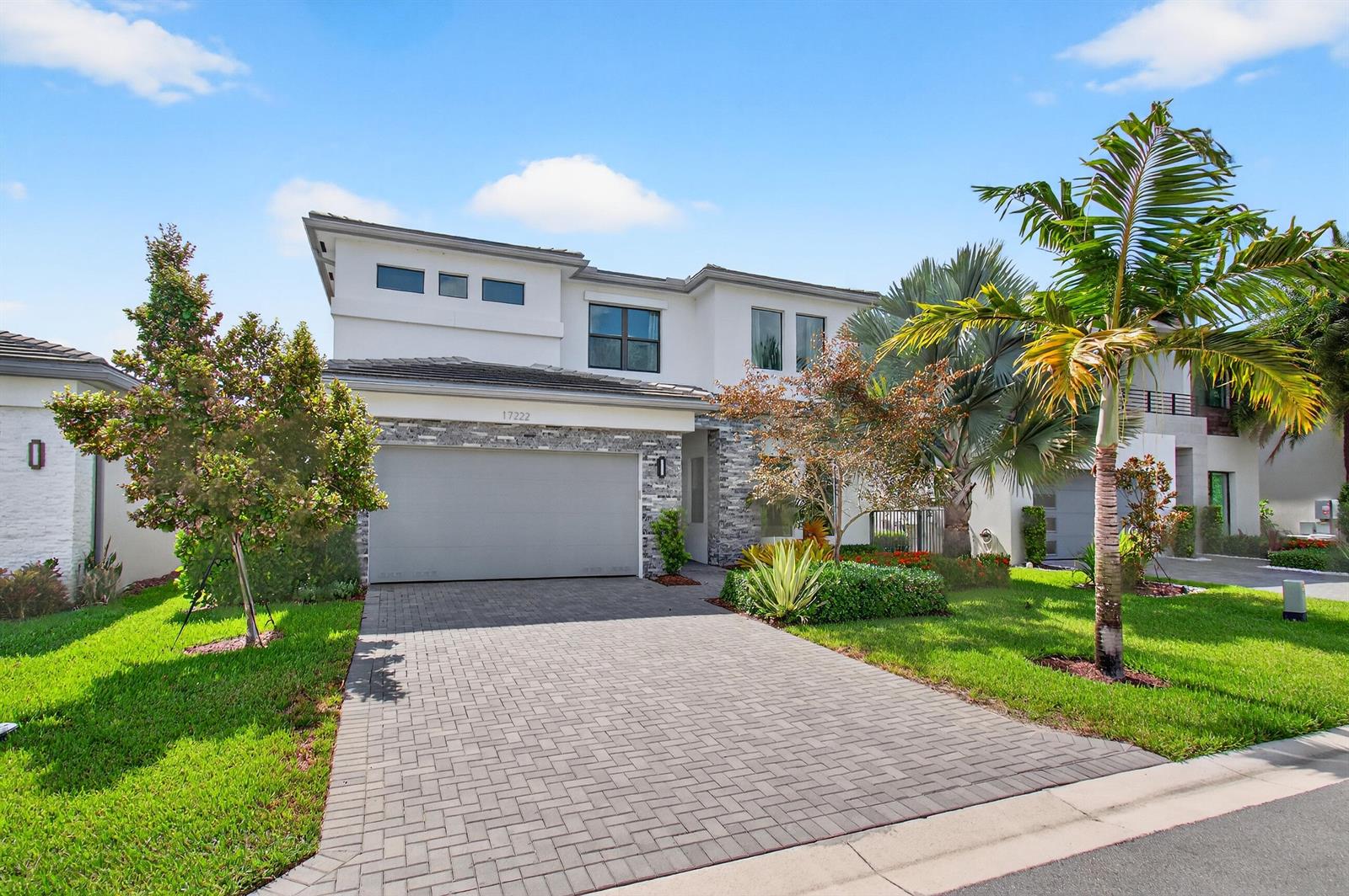 A two-story house with a gray garage, stone accents, and a paved driveway — 17222 Blue Bayou Drive, Boca Raton FL 33496, BOCA RATON, FL