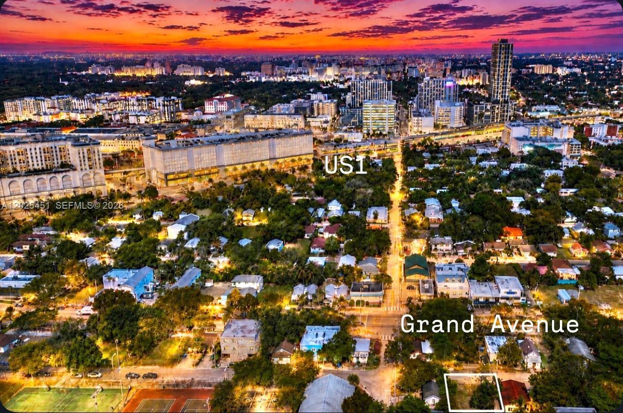 An aerial view shows a vacant lot in a residential neighborhood near a city skyline — 3828 Washington Ave, Miami FL 33133, MIAMI, FL