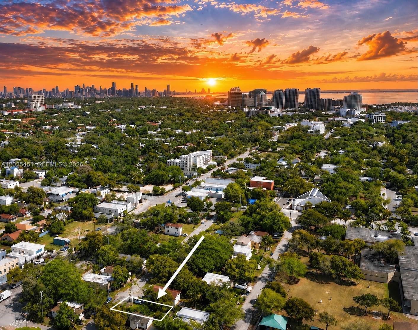 An aerial view shows a residential lot highlighted by an arrow against a sunset skyline — 3828 Washington Ave, Miami FL 33133, MIAMI, FL
