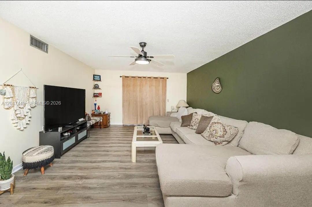 A kitchen with white cabinets, a wall-mounted oven, a refrigerator, and a small dining table — 2615 NE 3rd Ct # 4030, Boynton Beach FL 33435, BOYNTON BEACH, FL