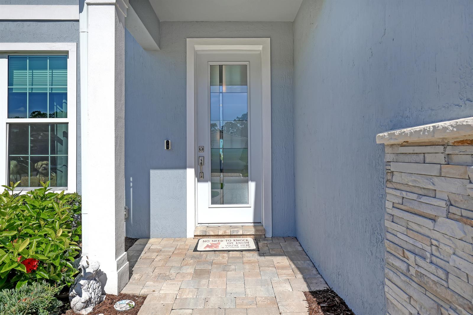 A front entryway features a white door with a glass panel and a stone-tiled porch — 9774 SW Meridian Way, Stuart FL 34997, STUART, FL