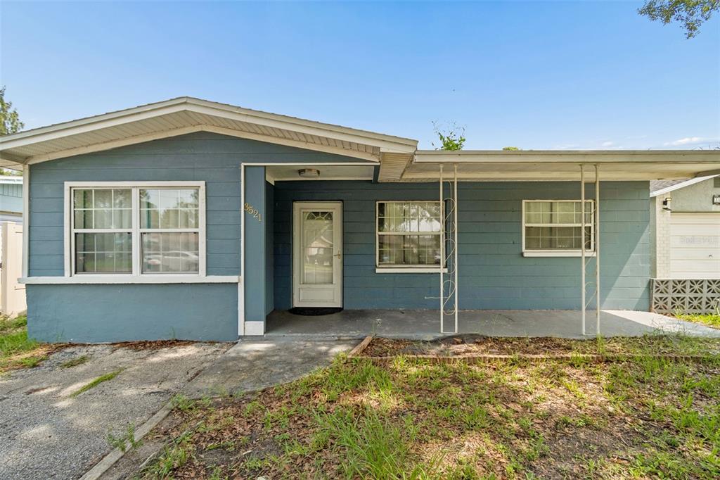 A single-story blue house with a covered front porch and a concrete driveway — 3521 74TH AVENUE N, PINELLAS PARK, FL