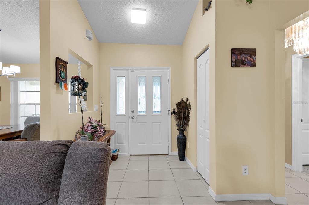 An entryway features light-colored tile flooring, a white front door, and a beige wall color — 5193 SW 110TH PLACE, OCALA, FL