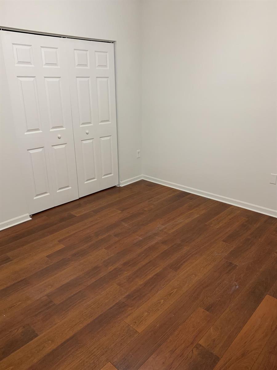 An empty room features white walls, a white bifold closet door, and wood-look flooring — 2080 Greenview Shores Boulevard # 404, FL, FL