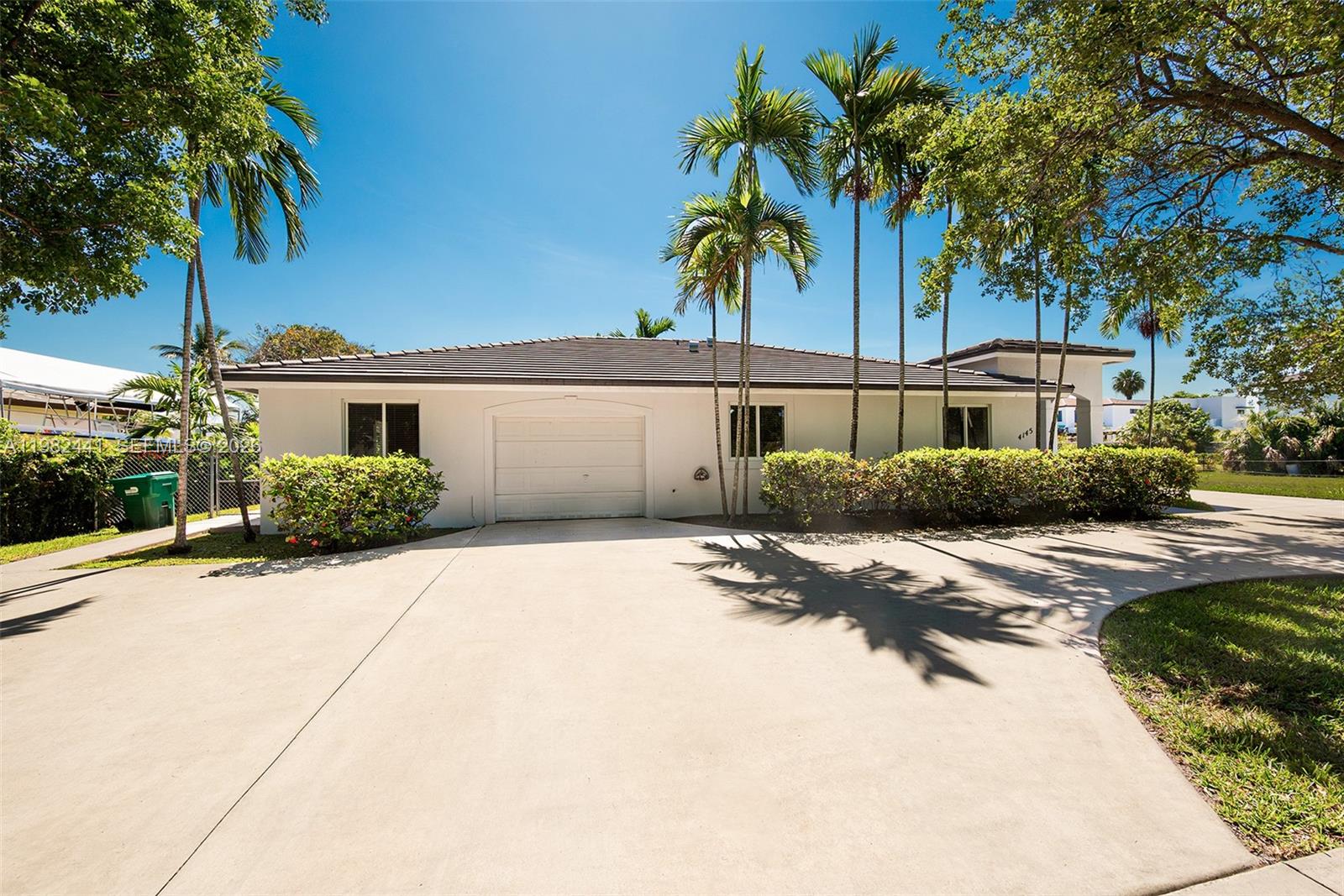 A single-story white house with a garage and palm trees sits behind a paved driveway — 4145 SW 84th Ct, Miami FL 33155, MIAMI, FL
