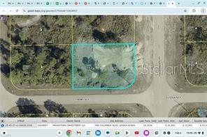 This is a satellite map view showing a vacant rectangular lot outlined in blue — 946 COLUMBUS BOULEVARD S, LEHIGH ACRES, FL