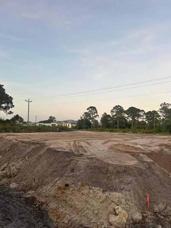 A cleared, graded dirt lot features a raised building pad under a clear sky — 946 COLUMBUS BOULEVARD S, LEHIGH ACRES, FL