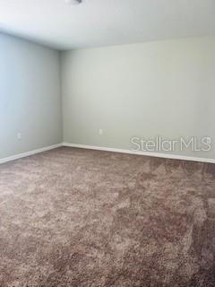 An empty room with light gray walls and brown wall-to-wall carpeting — 1005 FORESHORE LANE, HAINES CITY, FL