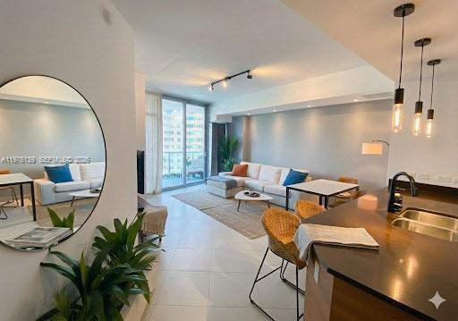A modern living room with a white sectional sofa, dining area, and kitchen island — 3301 NE 1st Ave # H1608, Miami FL 33137, MIAMI, FL