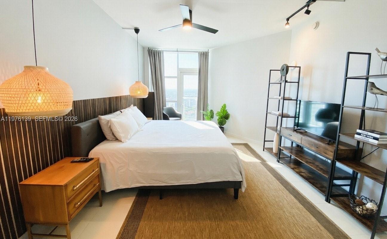 A modern bedroom features a king bed, wood-slatted headboard, two pendant lights, and shelving units — 3301 NE 1st Ave # H1608, Miami FL 33137, MIAMI, FL