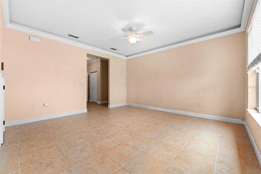 An empty room with light-colored walls, tile flooring, a ceiling fan, and a doorway — 231 ALEXANDER WOODS DRIVE, PLANT CITY, FL