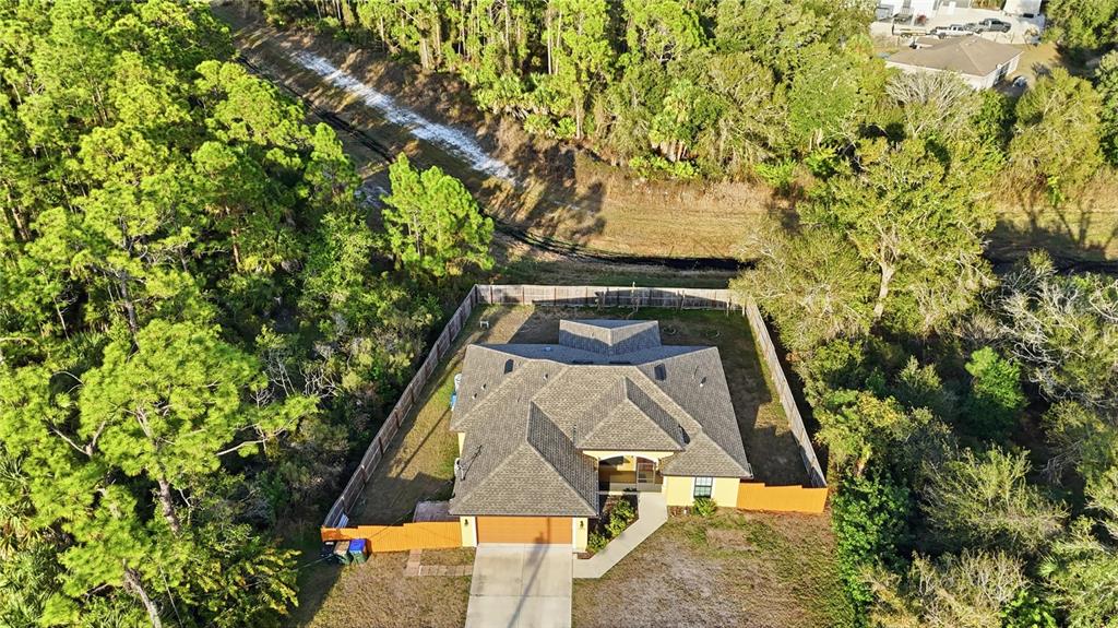 An aerial view shows a single-story house with a shingled roof and fenced backyard — 3018 BARRY ROAD, NORTH PORT, FL