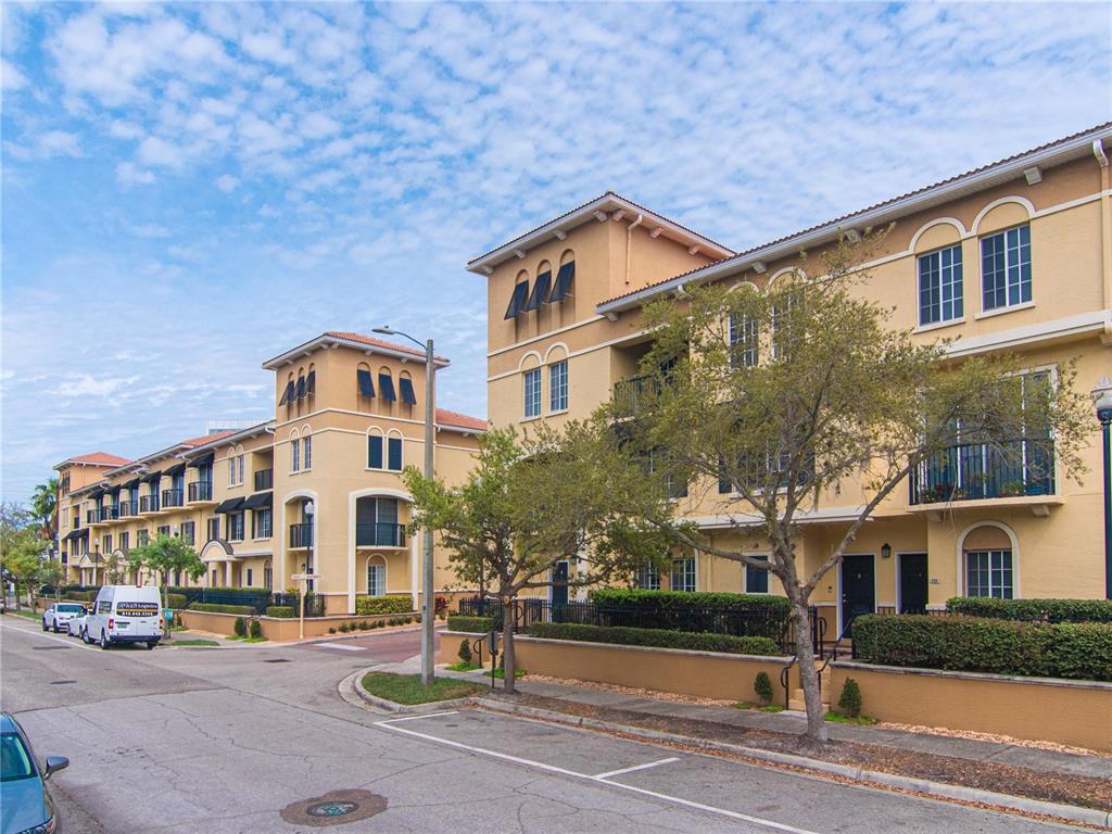 A street view of multi-story tan stucco apartment buildings with balconies and dark awnings — 126 S OBRIEN STREET, TAMPA, FL