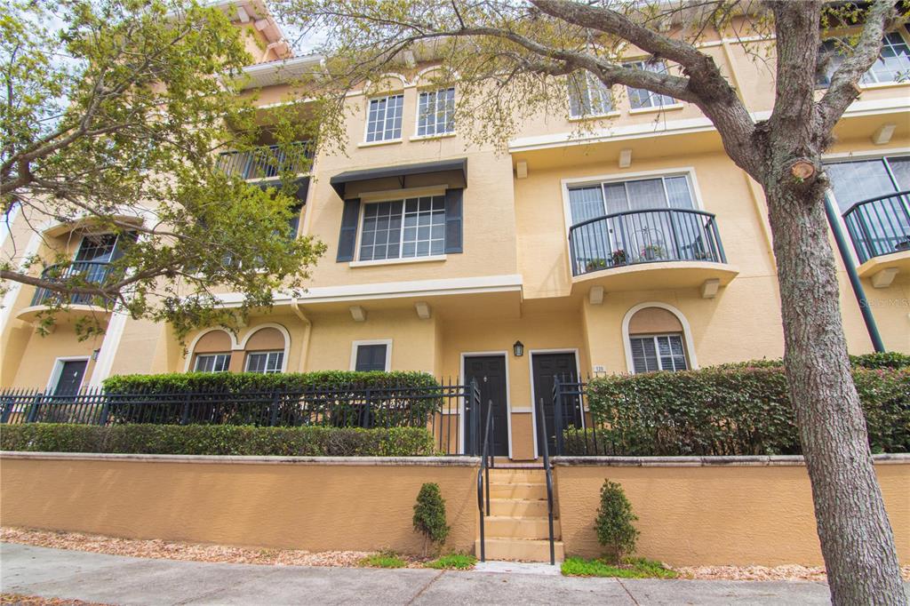 A three-story tan stucco townhouse with black railings, balconies, and a small front staircase — 126 S OBRIEN STREET, TAMPA, FL