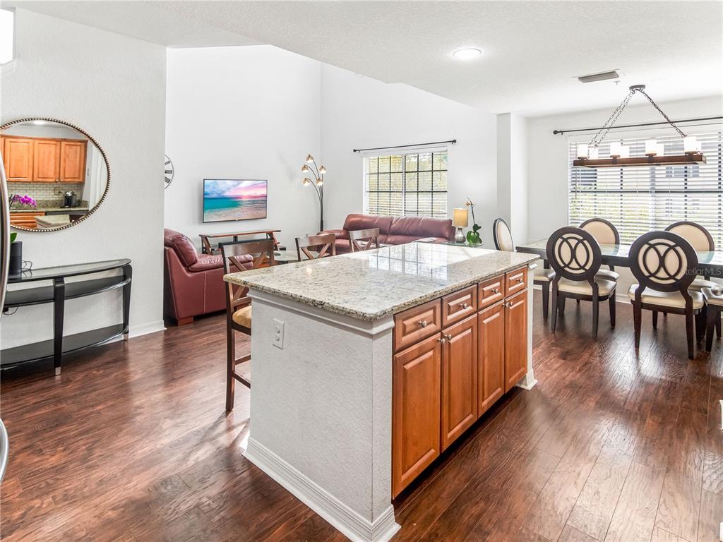 An open-concept kitchen island with granite countertops faces a living area and dining space — 126 S OBRIEN STREET, TAMPA, FL