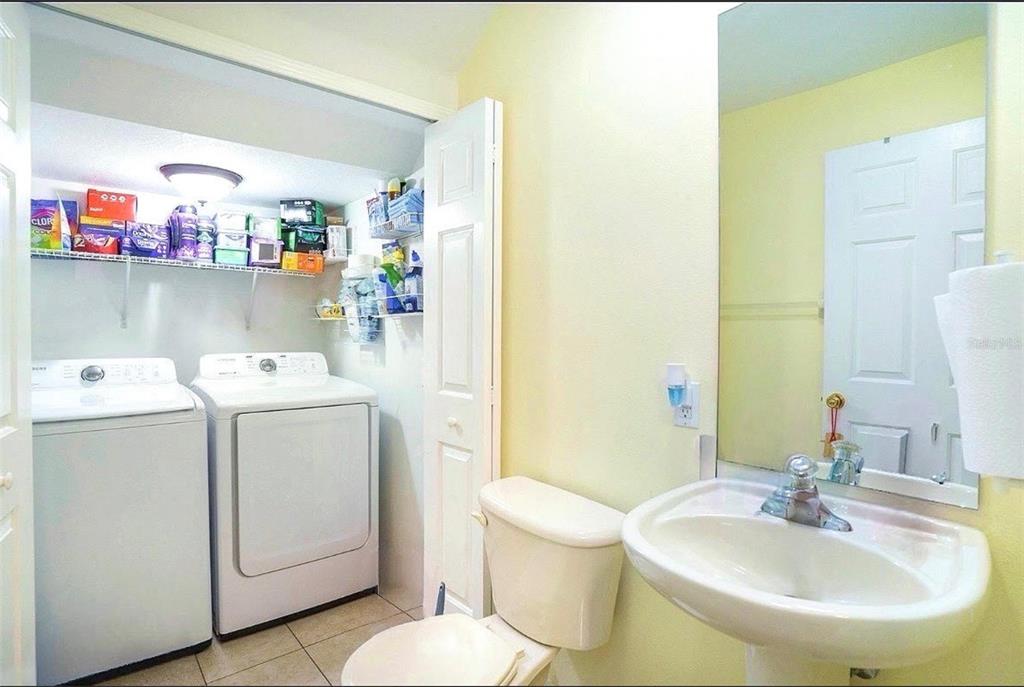A laundry room and bathroom combination featuring a washer, dryer, toilet, and pedestal sink — 3869 ISLAND WAY, ST PETERSBURG, FL