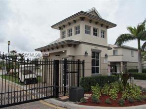 A gated entrance building with a tower structure and a golf cart parked nearby — 2004 Marsh Harbor Dr, Riviera Beach FL 33404, RIVIERA BEACH, FL