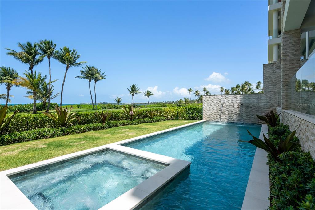 A private swimming pool and hot tub overlook a grassy lawn and tropical palm trees — Bahia Beach Resort OCEAN DRIVE UNIT 3102, RIO GRANDE, PR