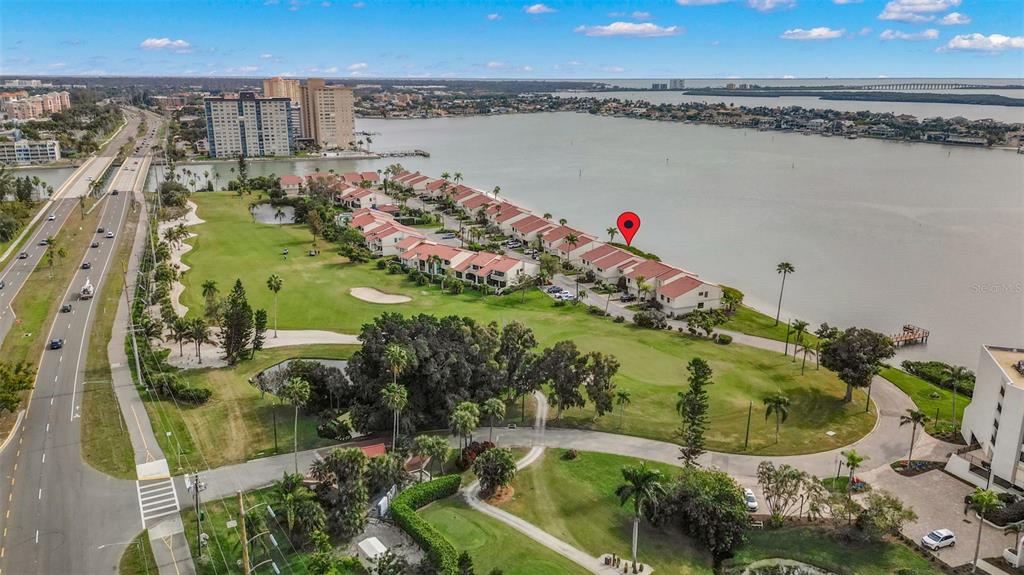 An aerial view shows a waterfront residential complex situated next to a golf course — 5668 ESCONDIDA BOULEVARD S, ST PETERSBURG, FL