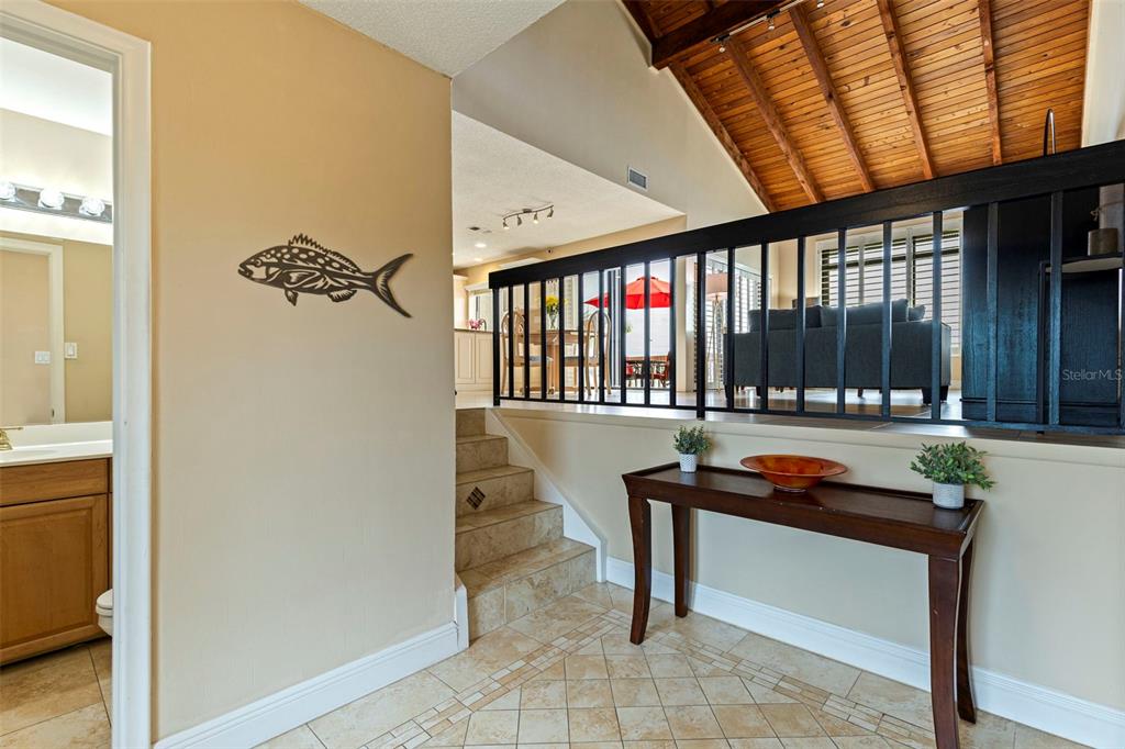 A tiled entryway leads to a raised living area with a wood-paneled vaulted ceiling — 5668 ESCONDIDA BOULEVARD S, ST PETERSBURG, FL