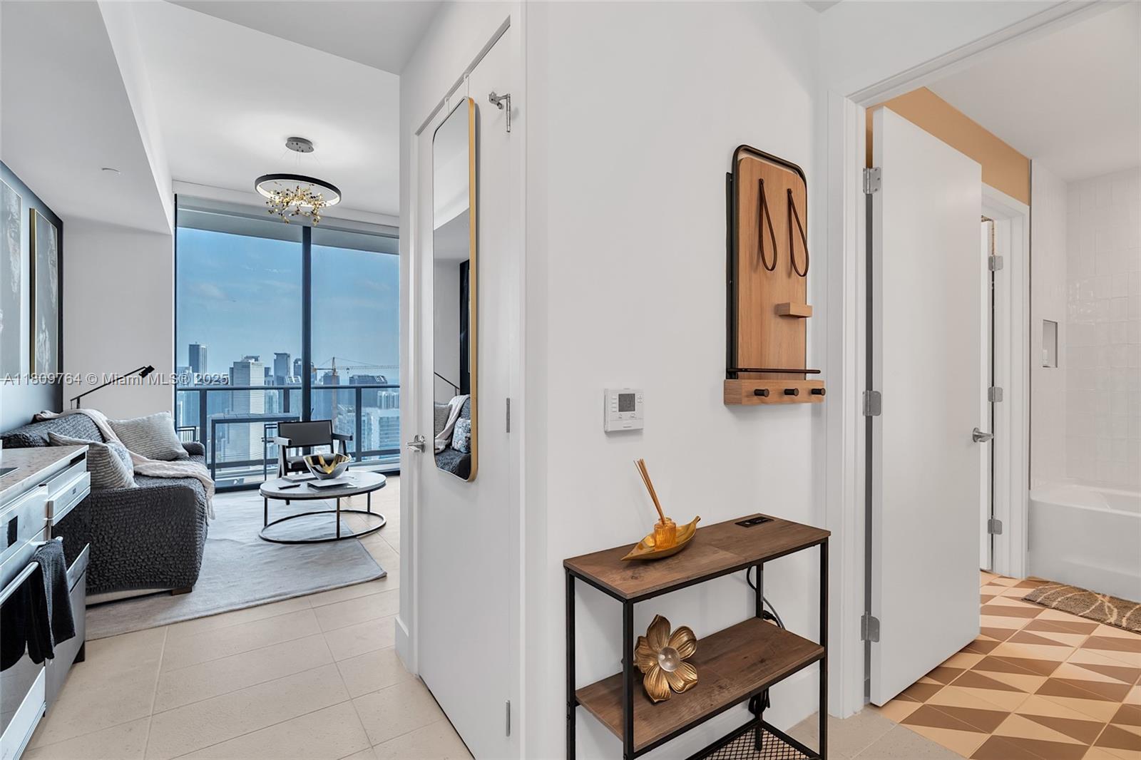 A hallway leads to a living area with floor-to-ceiling windows and city views — 601 NE 1st Ave # 4907, Miami FL 33132, MIAMI, FL