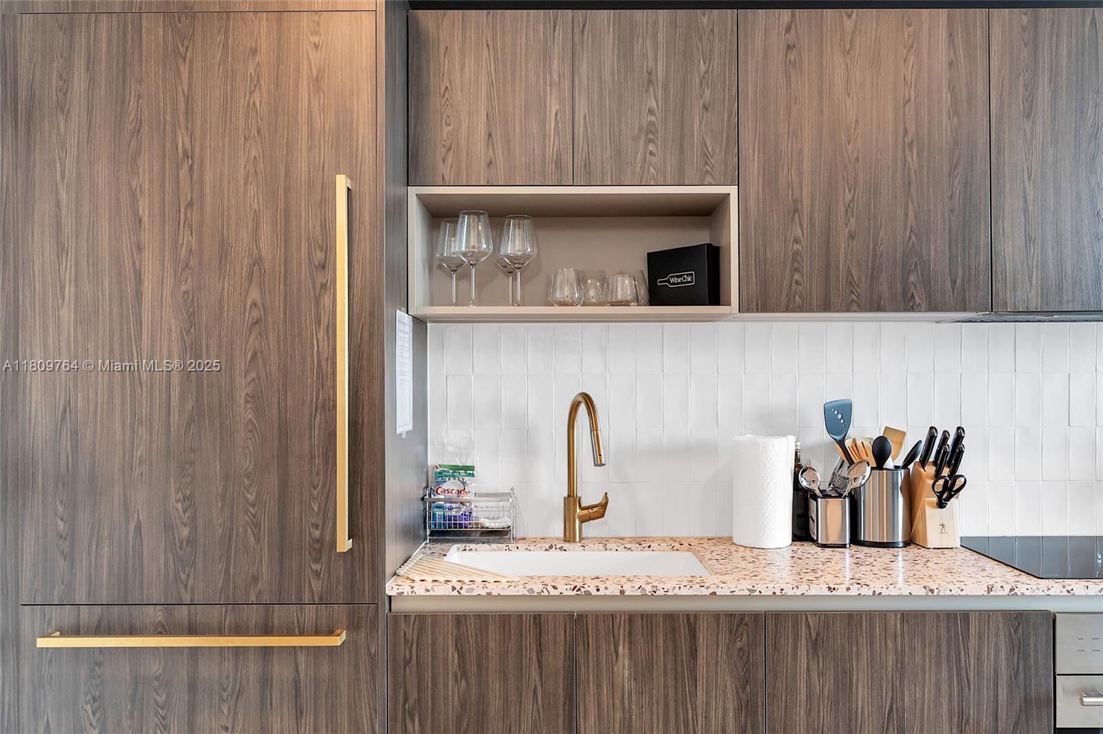 A modern kitchen features wood-grain cabinetry, a terrazzo countertop, and a gold faucet — 601 NE 1st Ave # 4907, Miami FL 33132, MIAMI, FL