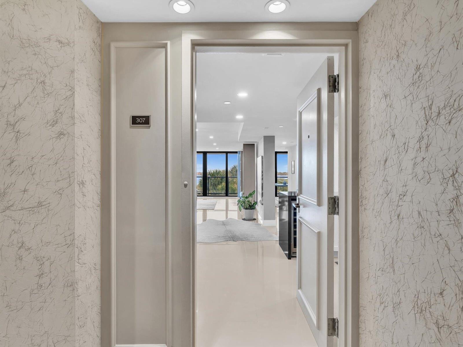 A view through an open doorway into a bright apartment with light tile flooring — 3440 S Ocean Boulevard # 307n, Palm Beach FL 33480, PALM BEACH, FL