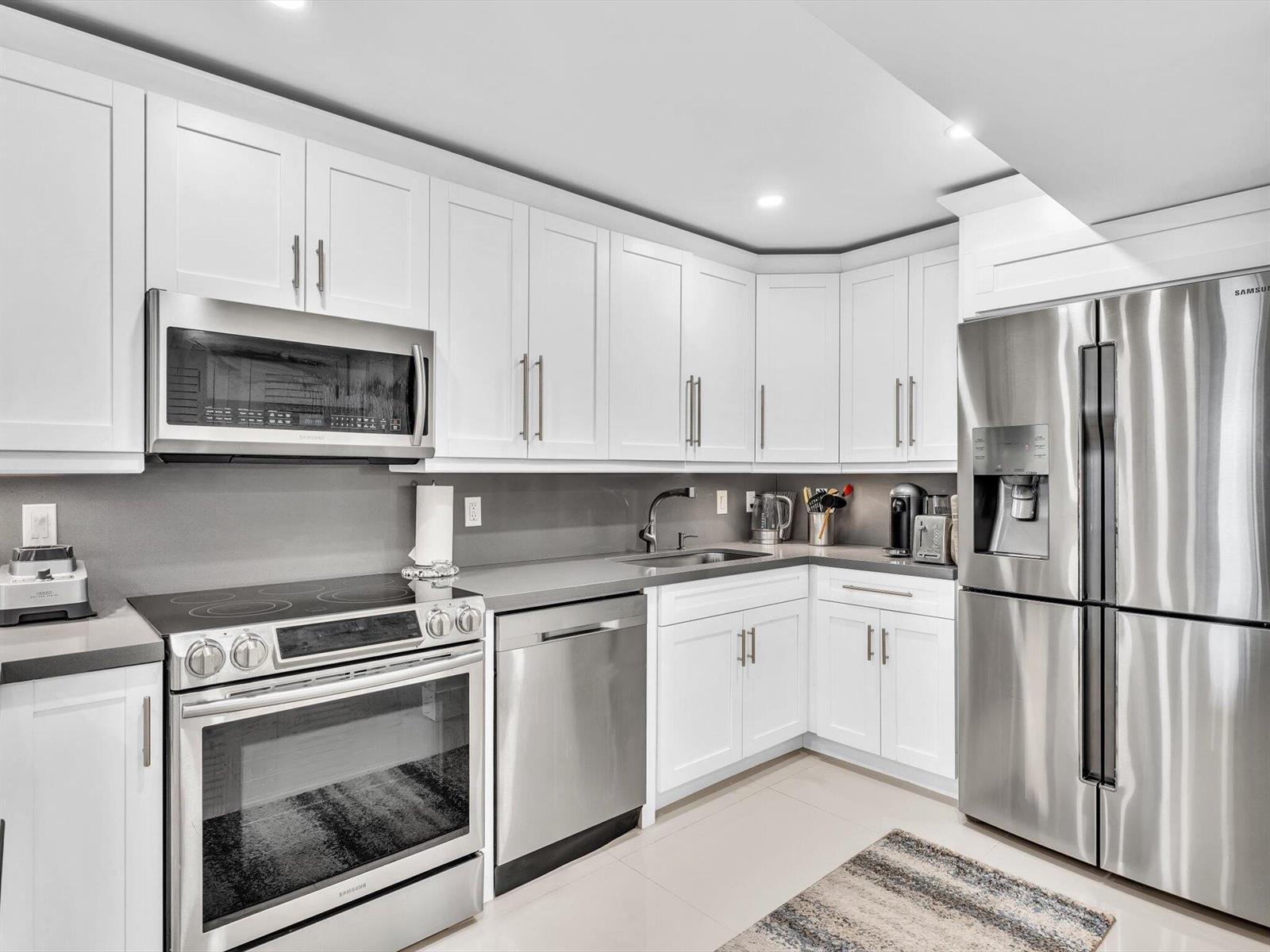 A kitchen with white cabinets, stainless steel appliances, and gray countertops — 3440 S Ocean Boulevard # 307n, Palm Beach FL 33480, PALM BEACH, FL