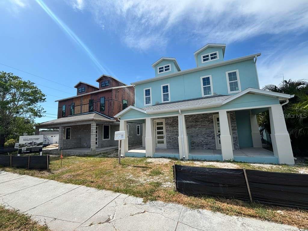Two multi-story houses under construction with light blue and unfinished wood exteriors — 6177 1ST AVENUE N, ST PETERSBURG, FL