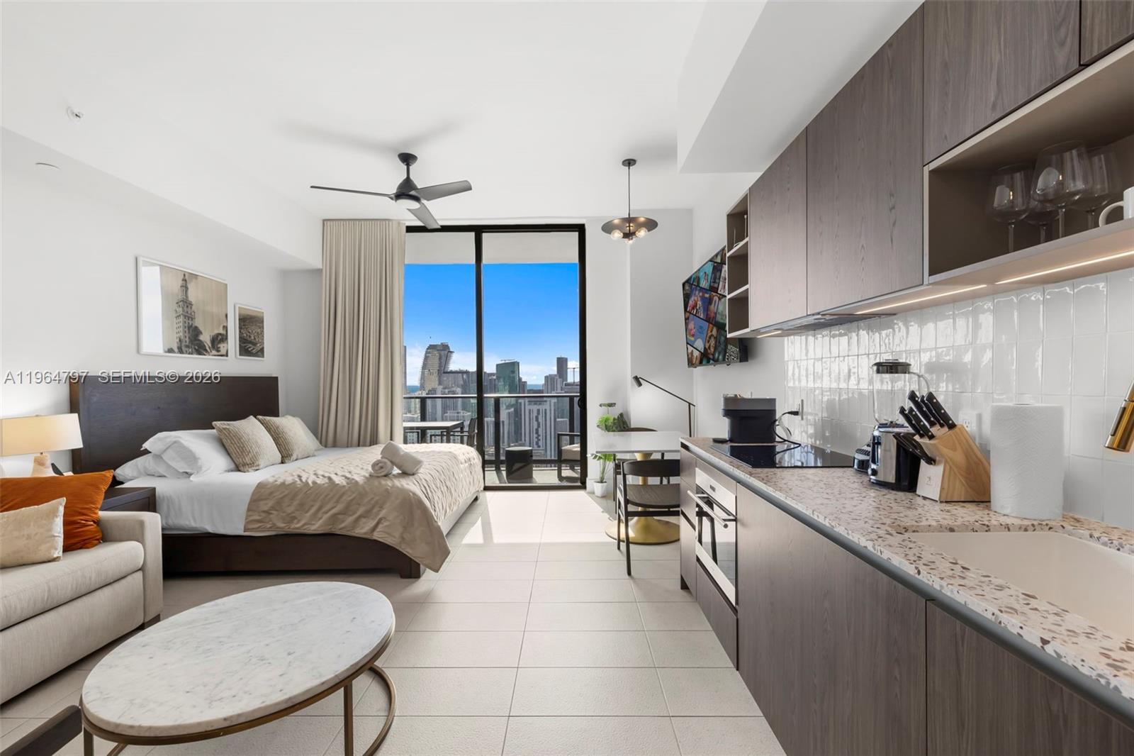 A studio apartment features a kitchenette, a bed, a living area, and a balcony view — 159 NE 6th St # 4910, Miami FL 33132, MIAMI, FL
