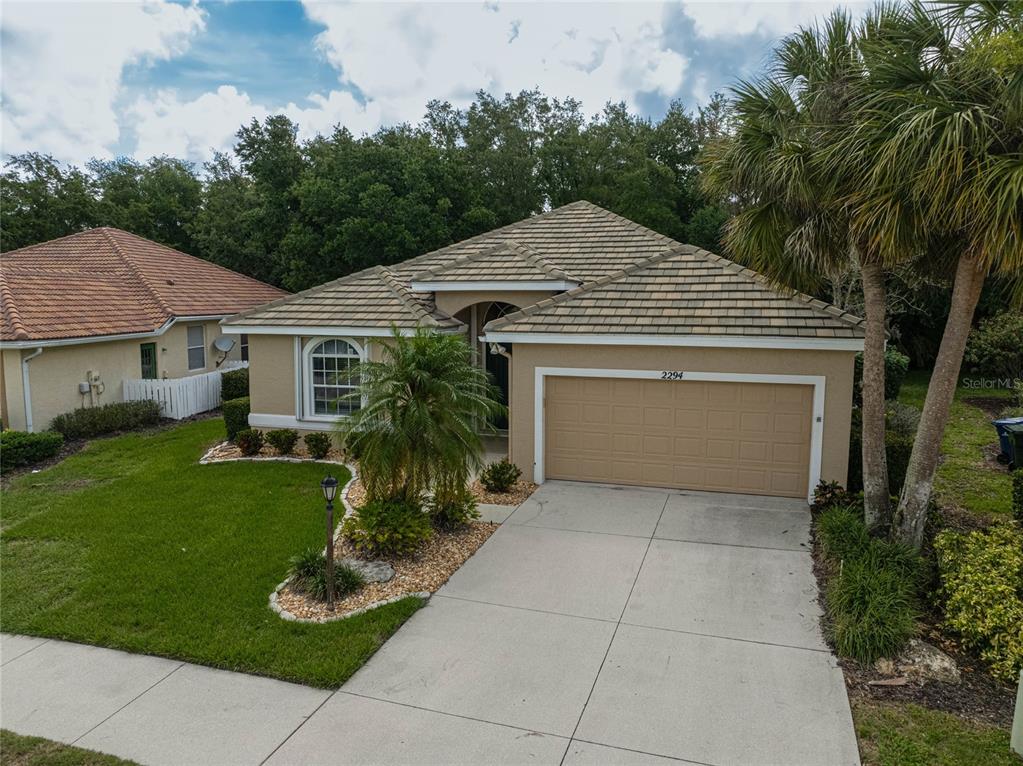 A tan single-story house with a two-car garage and a tiled roof — 2294 HARRIER WAY, NOKOMIS, FL