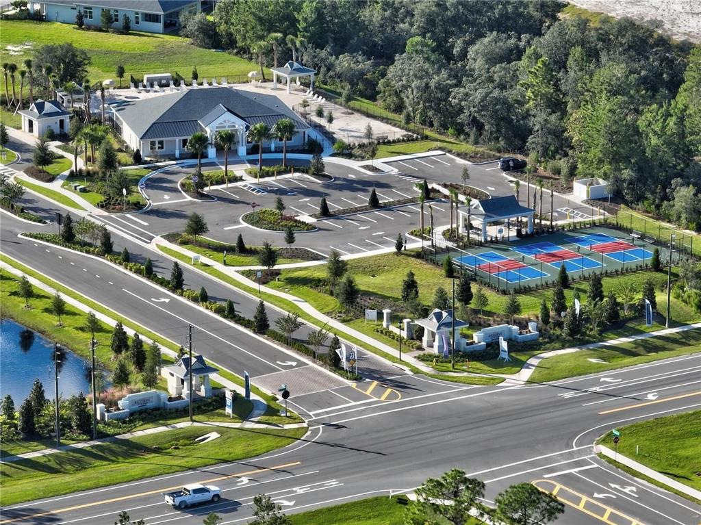 An aerial view shows a community clubhouse with a parking lot and tennis courts — 938 MEGANO BOULEVARD, DELAND, FL