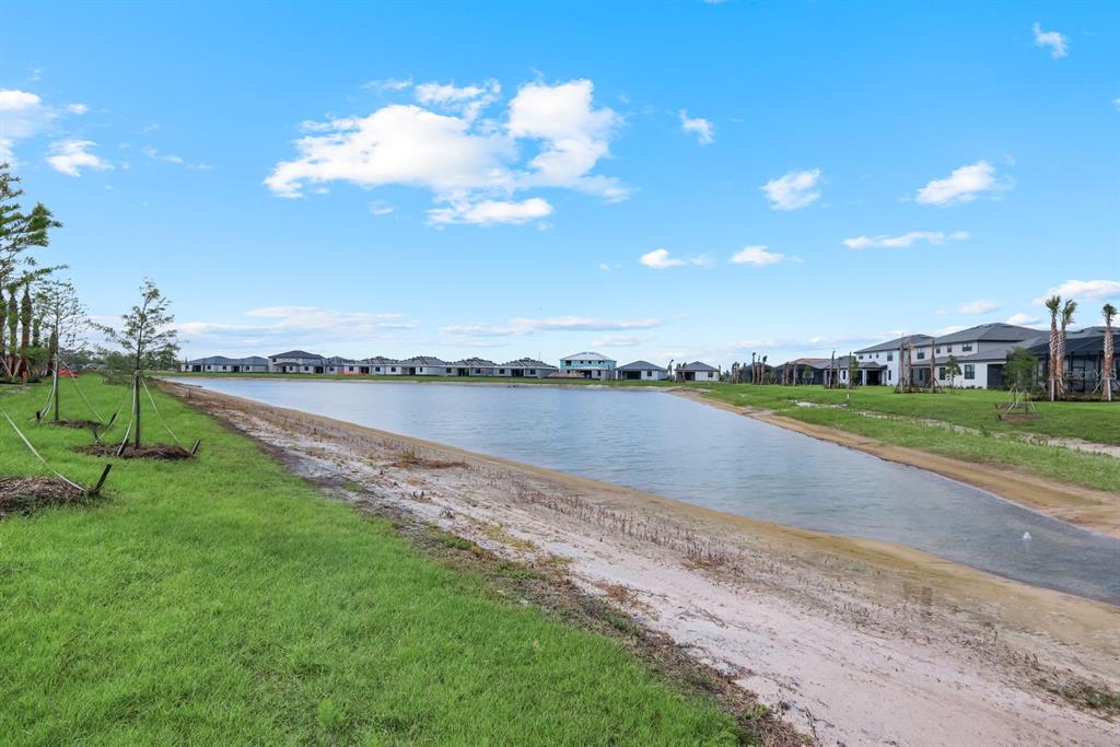 A view of a retention pond surrounded by newly constructed houses and young trees — 19232 GENTRY PLACE, ESTERO, FL