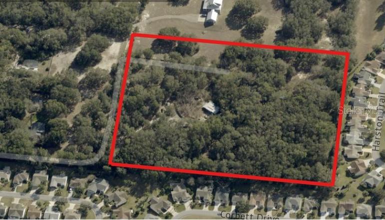 An aerial view shows a large, rectangular wooded lot outlined in red near residential streets — 8801 NE 90TH TRAIL, FRUITLAND PARK, FL
