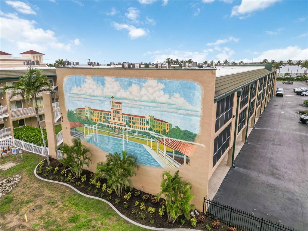 An exterior view of a building featuring a large mural of a hotel and pool — 150 HARBORSIDE AVENUE UNIT 307, PUNTA GORDA, FL
