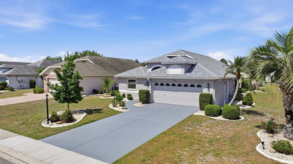 A single-story house with a gray roof, light-colored siding, and a paved driveway — 1834 E DEL WEBB BOULEVARD, SUN CITY CENTER, FL