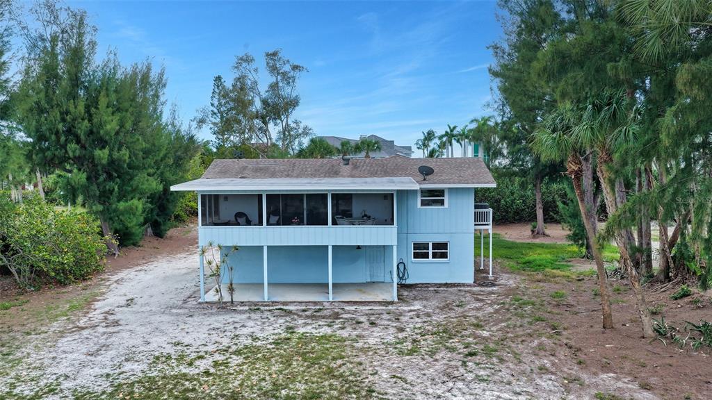 An elevated light blue house with a screened-in porch and a covered ground-level patio — 6664 & 6660 & 6670 GULF OF MEXICO DRIVE, LONGBOAT KEY, FL