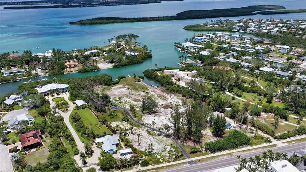 An aerial view shows a coastal property with a large vacant lot and surrounding homes — 6664 & 6660 & 6670 GULF OF MEXICO DRIVE, LONGBOAT KEY, FL