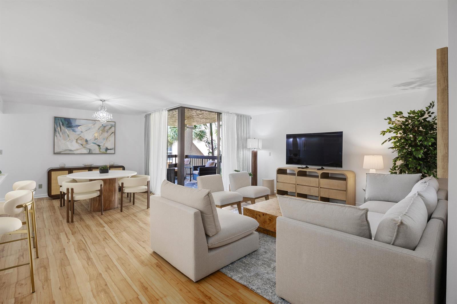 A bright living and dining area with light wood floors, neutral furniture, and a balcony — 750 Egret Circle # 6210, Delray Beach FL 33444, DELRAY BEACH, FL
