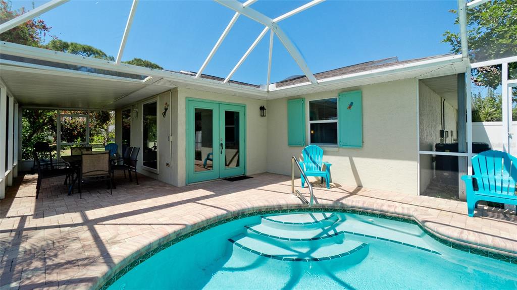 A screened-in patio features a swimming pool, outdoor furniture, and light-colored exterior walls — 8403 13TH AVENUE NW, BRADENTON, FL