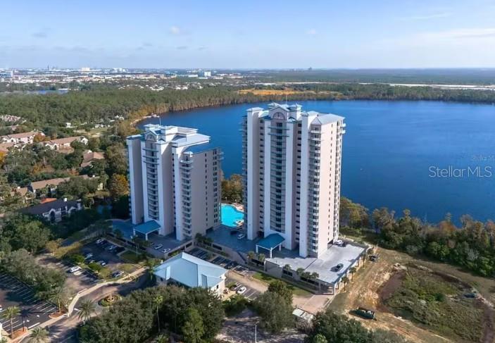 An aerial view shows two tall residential buildings situated next to a large lake — 13415 BLUE HERON BEACH DRIVE UNIT 403, ORLANDO, FL