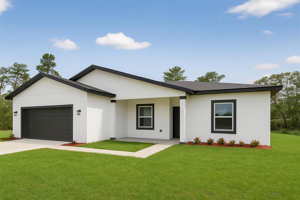 A single-story white house with a dark roof, garage, and front porch on a lawn — 15028 SW 25TH CIRCLE, OCALA, FL
