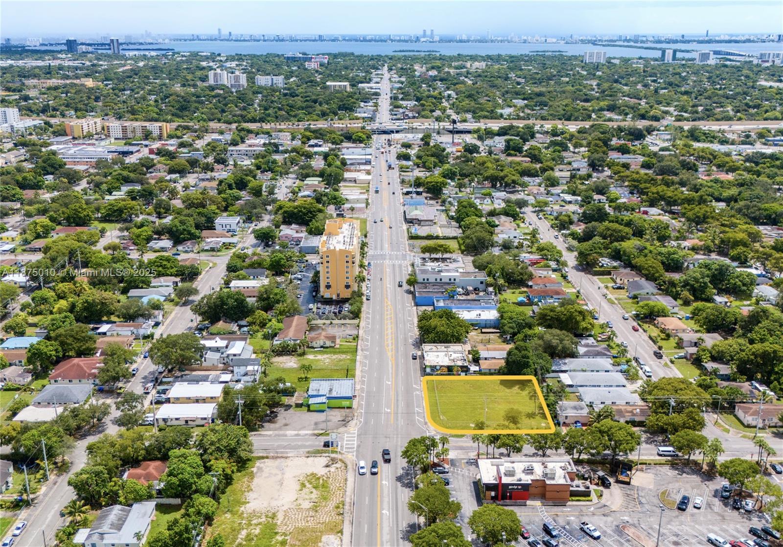 An aerial view shows a vacant rectangular lot highlighted in yellow along a busy road — 1090 NW 54th St, Miami FL 33127, MIAMI, FL